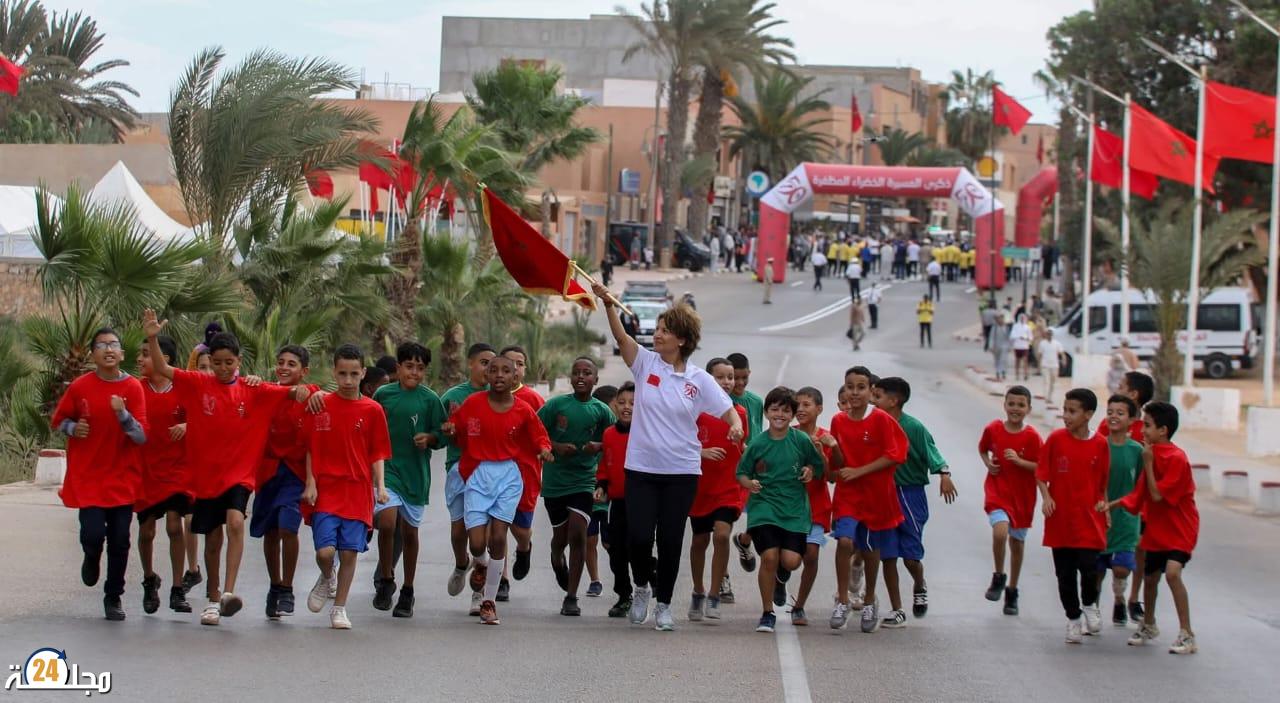 سباق التناوب الرمزي المسيرة الخضراء : البطلة نزهة بدوان تحمل العلم الوطني في المرحلة 11 بين طانطان وطرفاية