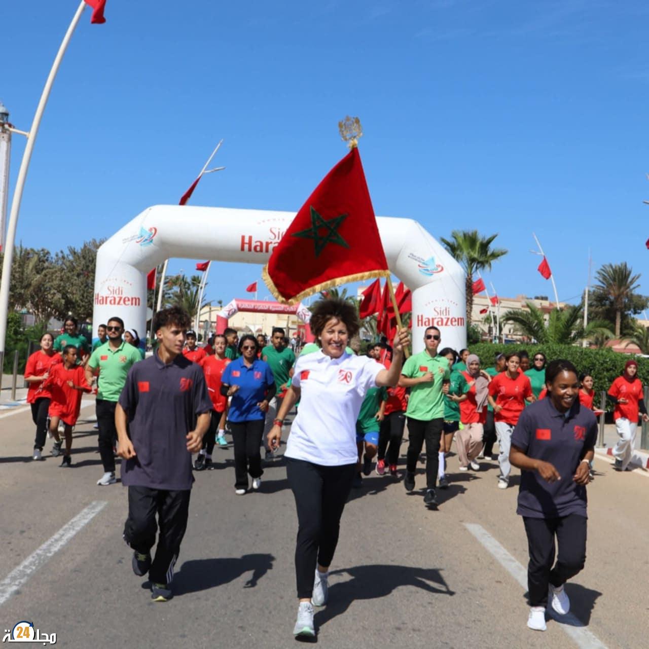 سباق التناوب الرمزي المسيرة الخضراء : البطلة نزهة بدوان  تحمل العلم الوطني في المرحلة 14  ( بوجدور- الكركرات).
